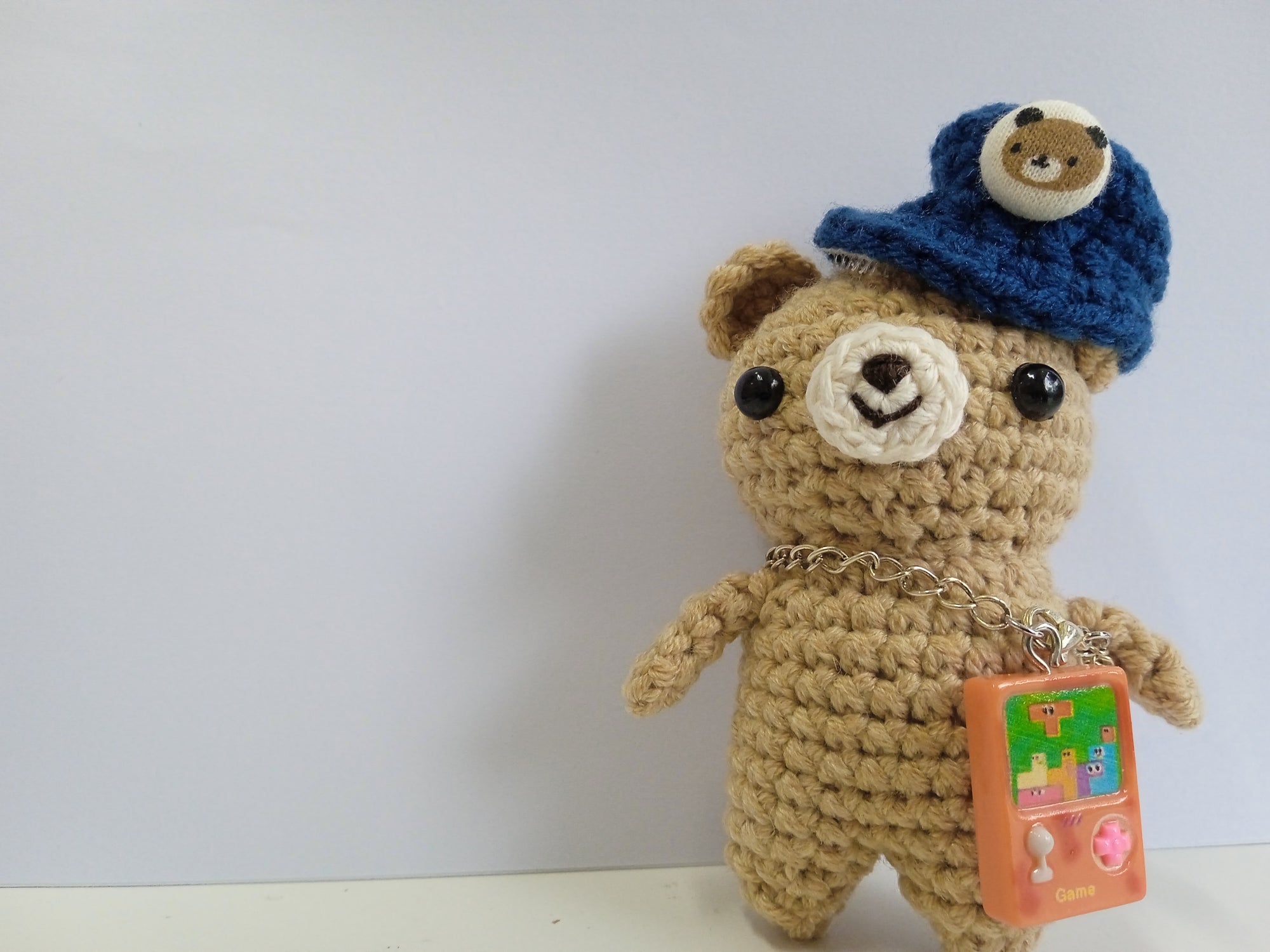 Crocheted teddy bear with a blue hat. Artisan made in Singapore. 
Stuffed animal photography