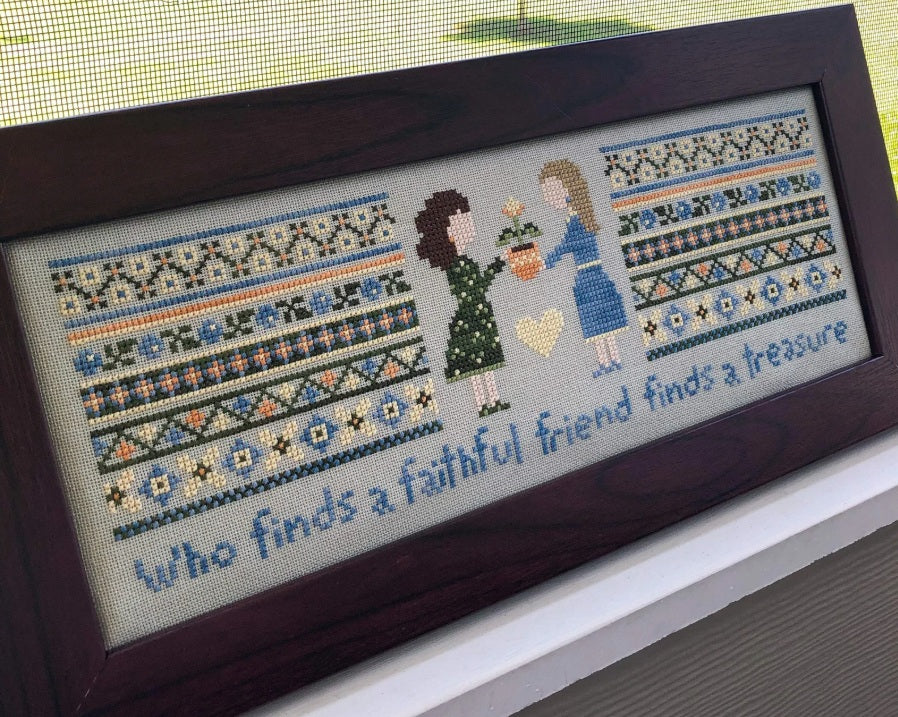 A professional-grade cross-stitch kit by Sweet Wing Studio titled 'Faithful Friends.' The high-definition design features a horizontal composition showing two human friends in a soulful, boutique-style illustration. Below the figures is the inspirational quote: 'Who finds a faithful friend finds a treasure.'