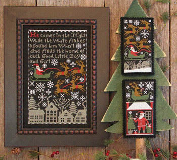 The Prairie Schooler Santa's Night cross-stitch showing Santa and reindeer flying across a snowy midnight sky on black fabric. 

Santa's Night Cross Stitch Kit, The Prairie Schooler Santa, Primitive Christmas Cross Stitch, Black Aida Christmas Kit, Prairie Schooler Book 175.