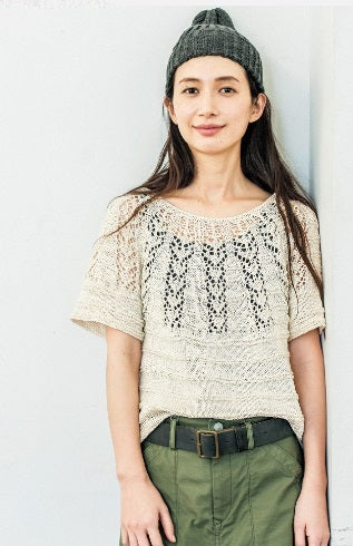 Close-up of the seamless shoulder transition on a knitted tunic with sleeves, highlighting the professional finish of neck-down construction