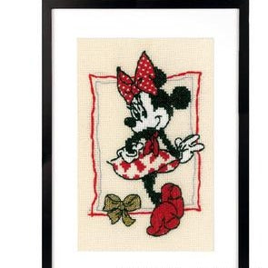 Cross-stitched design of a character with a red bow and checkered dress on beige fabric.