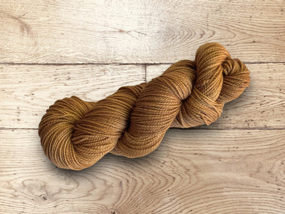 Brown yarn on a wooden surface. Sami Yarn by Manos del Uruguay. 100% Superwash yarn