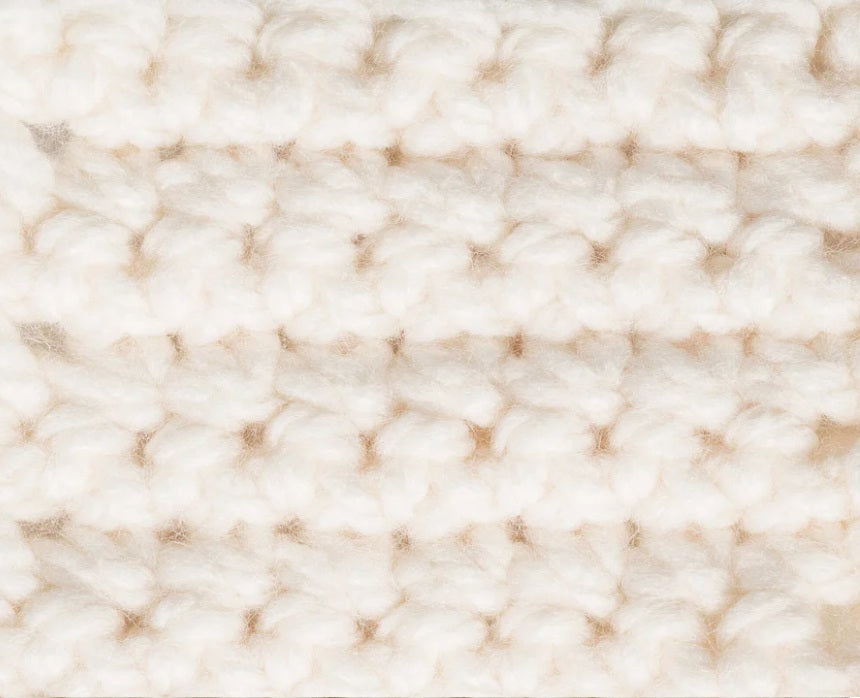 Close-up of a textured beige fabric 
Close-up of the plush, super bulky plies of Bernat Softee Chunky, highlighting the smooth stitch definition and lack of fuzz in natural crochet stitches