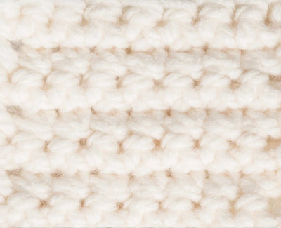 Close-up of a textured beige fabric 
Close-up of the plush, super bulky plies of Bernat Softee Chunky, highlighting the smooth stitch definition and lack of fuzz in natural crochet stitches