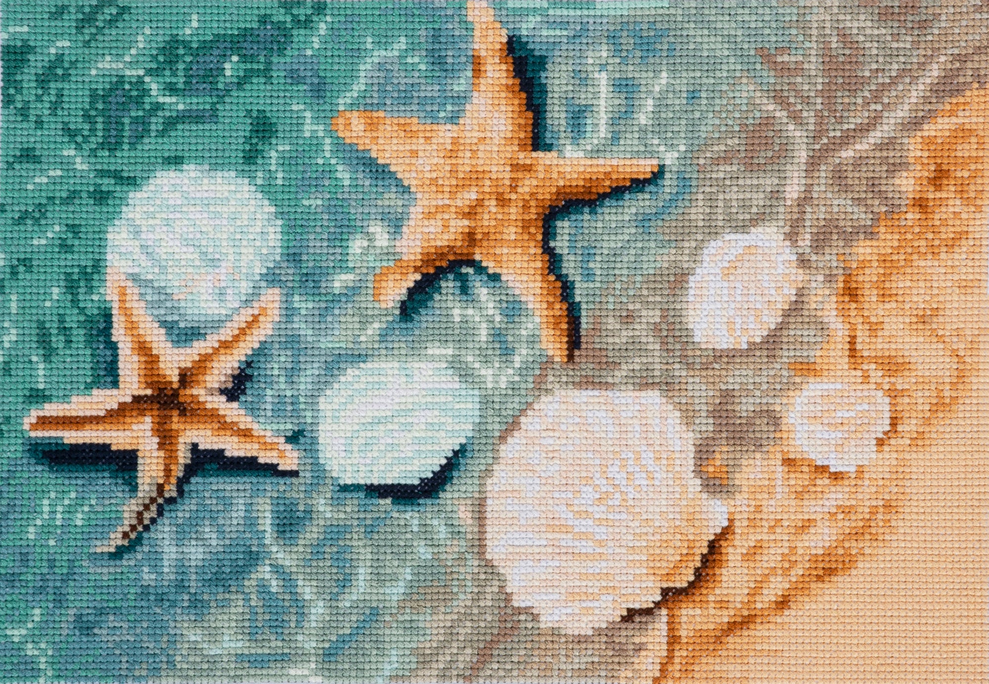 Cross-stitched design of starfish and shells on a textured fabric background