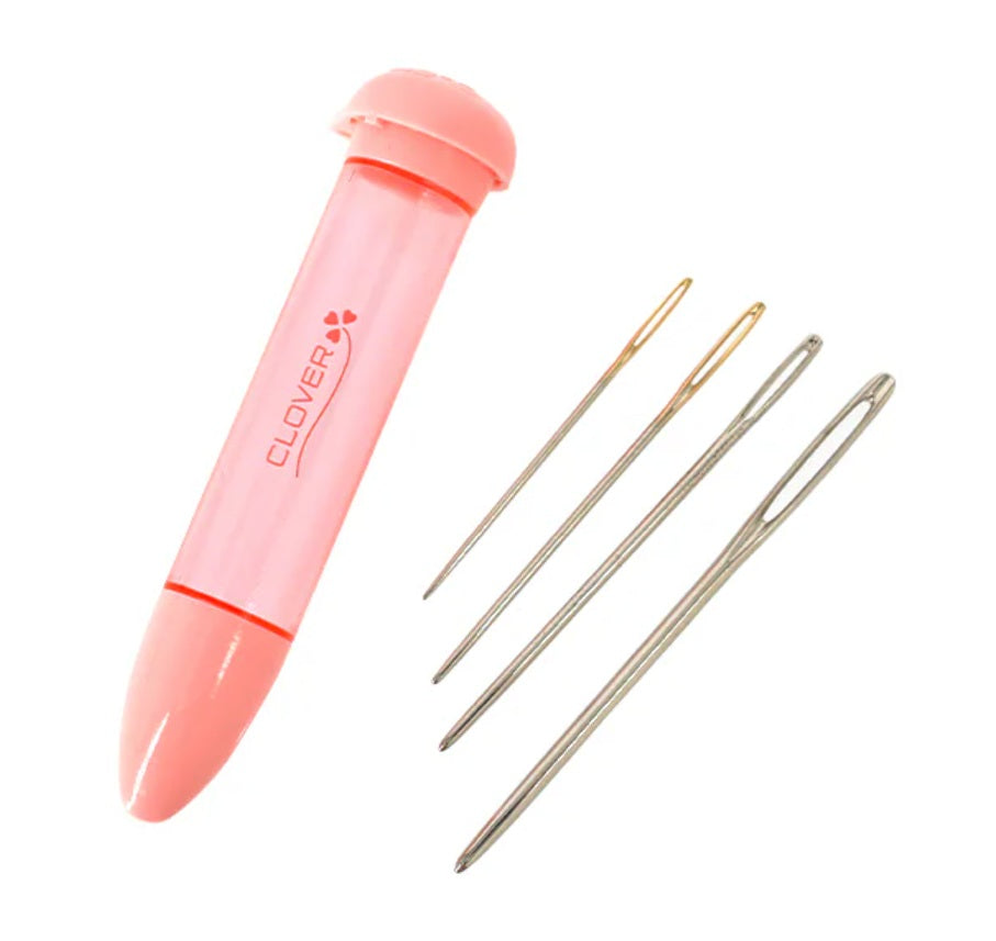 Pink needle case with needles on a white background clover brand darning needles