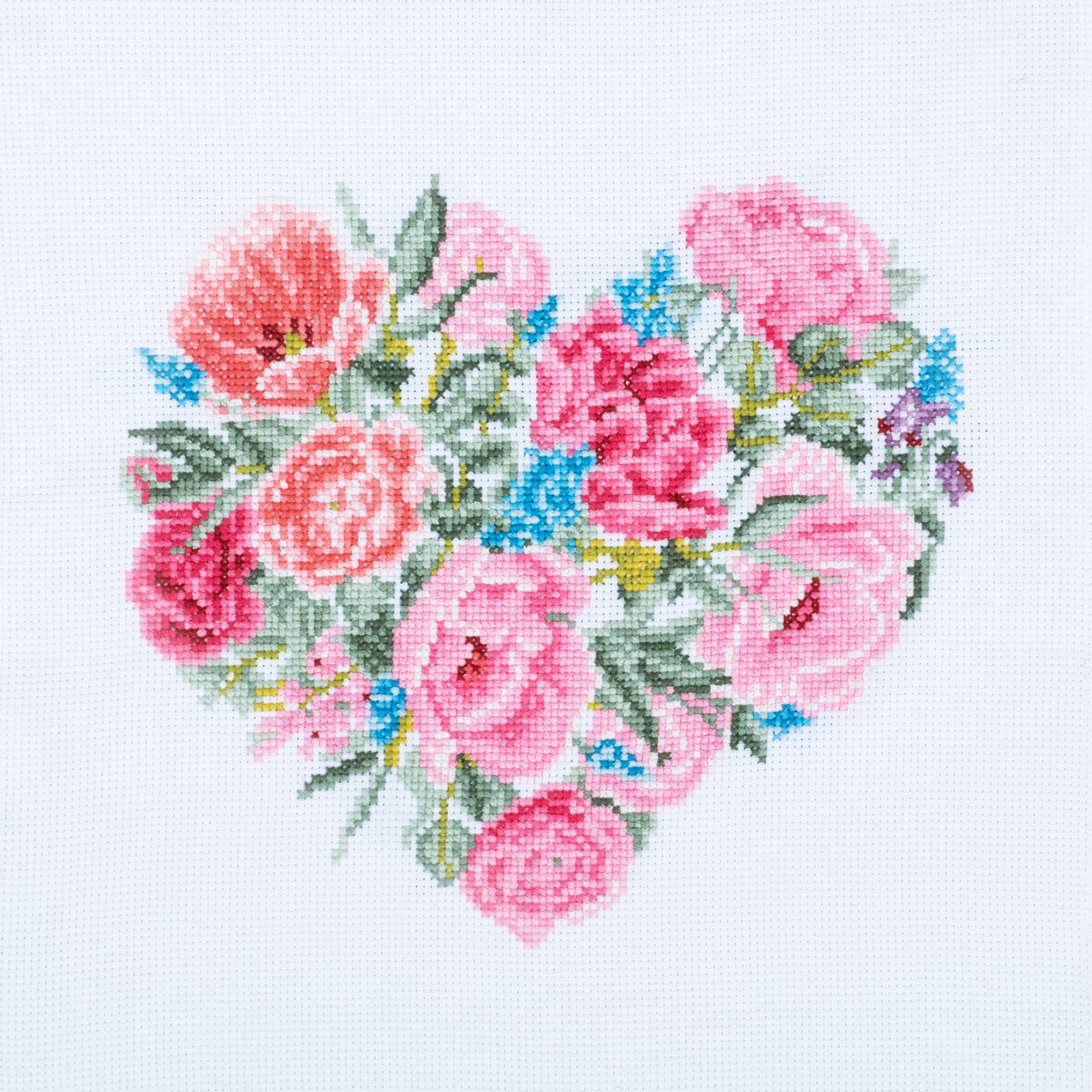 Cross stitch kit image showing a heart-shaped design with a floral pattern in pink, blue, and green colors on a white background.