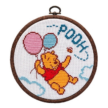 Cross-stitched design of Winnie the Pooh with balloons in a wooden hoop.