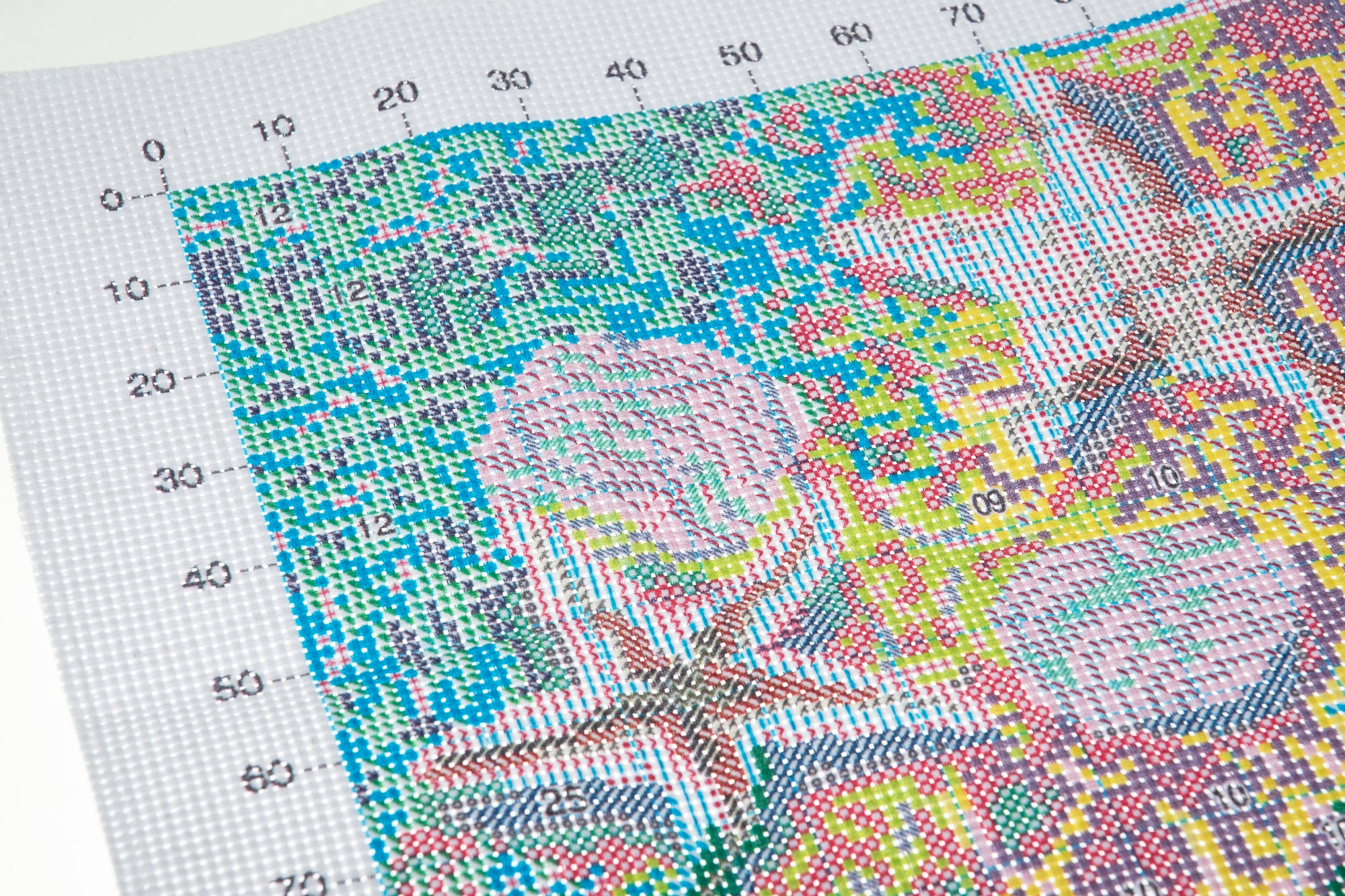 Cross-stitch pattern with colorful design on a grid background showing sea shells