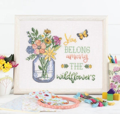 A comprehensive cross stitch book containing multiple charts for creating personalized home decor, including kitchen-themed motifs, welcome signs, and cozy living space patterns.