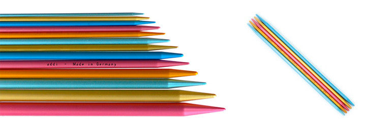 A set of colorful double-pointed knitting needles with turquoise handles and multicolored tips.