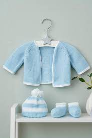 The book contains twelve exclusive English-language patterns for both knitting and crochet, featuring a range of newborn clothing, soft toys, nursery mobiles, and bedding accessories in a soft, modern aesthetic.