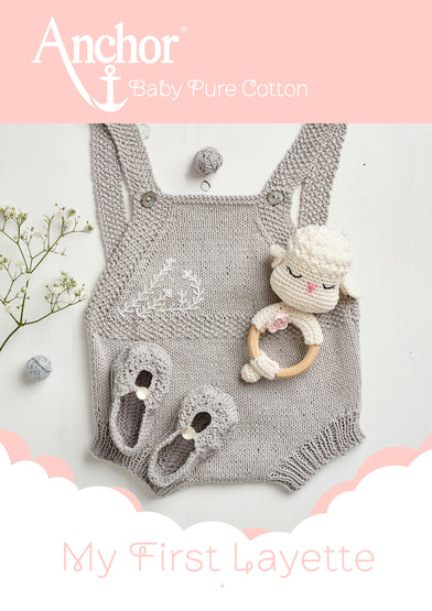 A knitting and crochet collection book for babies, showing a gray knitted romper, matching booties, and a teddy bear-shaped baby rattle, with the 'Anchor Baby Pure Cotton' logo and the title 'My First Layette' displayed.