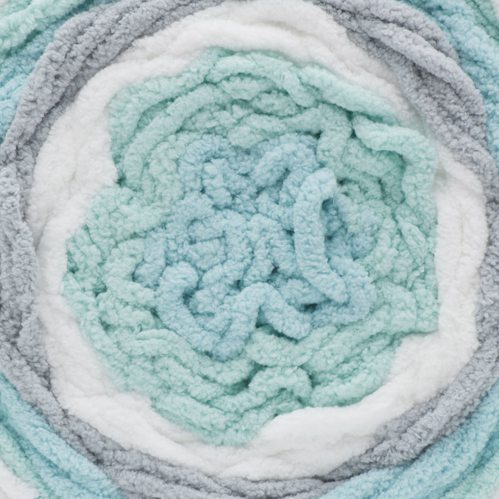 A ball of Bernat Baby Blanket Stripes yarn in mint green, gray, and white colors.