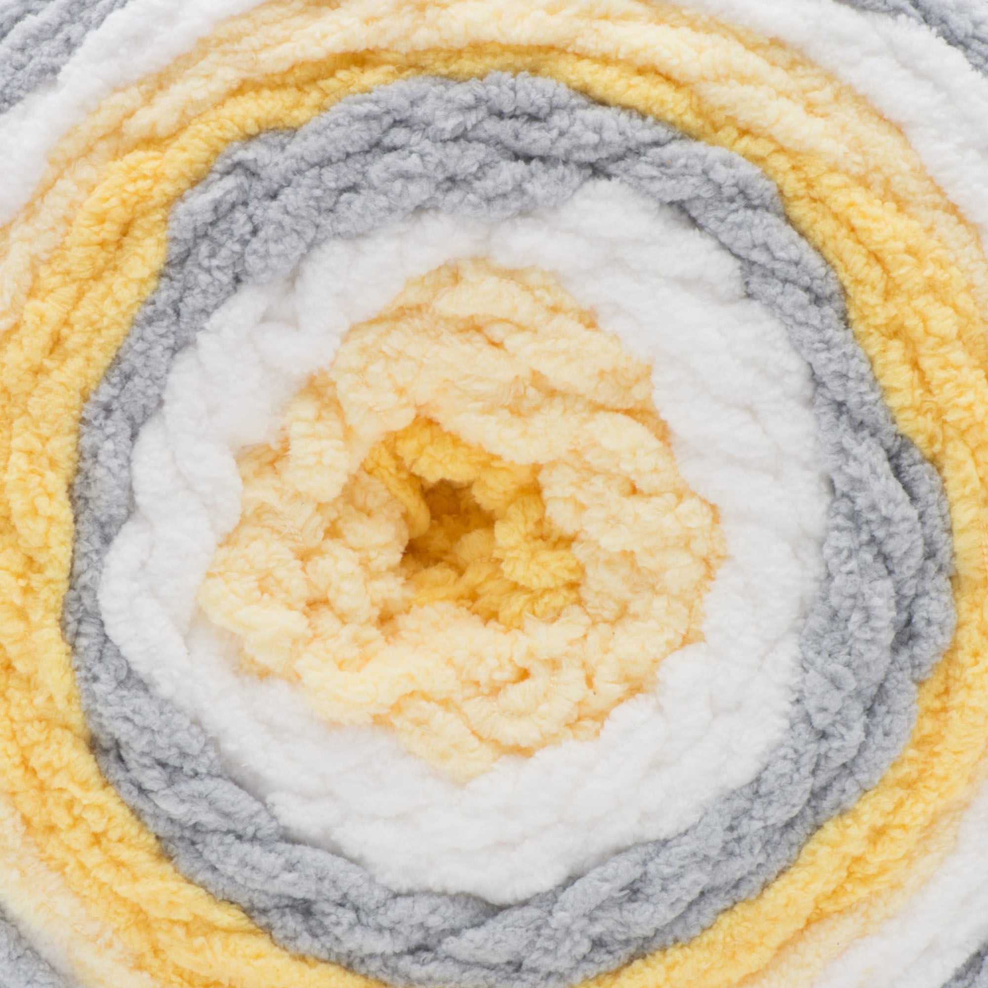 A ball of Bernat Baby Blanket Stripes yarn in yellow, gray, and white colors.