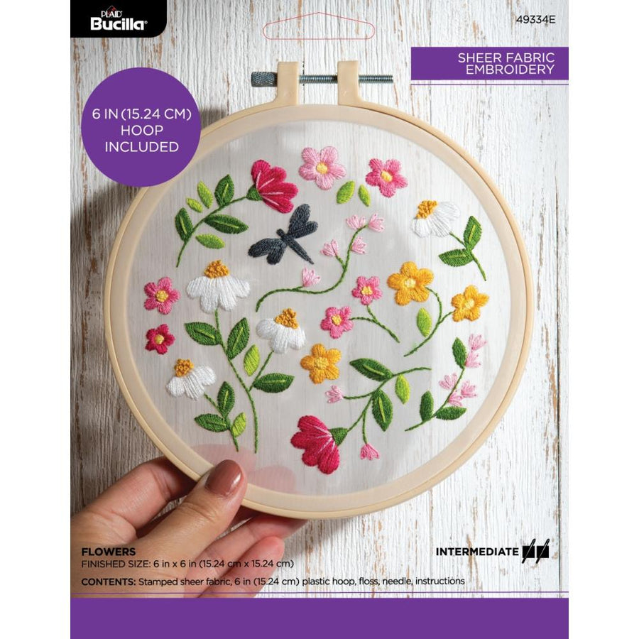 Packaging of a Bucilla stamped embroidery kit featuring a floral design, with a visible embroidery hoop and fabric.