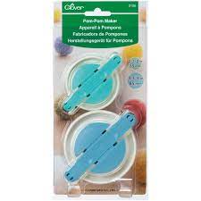A set of two Clover Pom-Pom makers in large sizes (65mm and 85mm), featuring a durable plastic circular design with fold-out metal arms. The tools are shown in their vibrant blue and green colors, designed for easy yarn wrapping and consistent pom-pom creation.