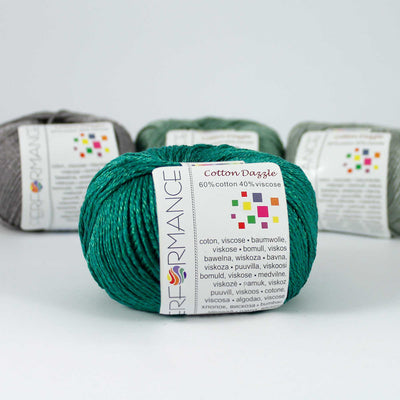 A 50g skein of Cotton Dazzle yarn in emerald green colour, showcasing the subtle reflective shimmer and smooth plied texture of the cotton-viscose blend."