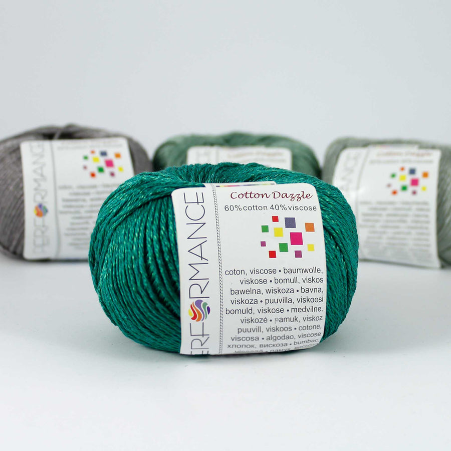 A 50g skein of Cotton Dazzle yarn in emerald green colour, showcasing the subtle reflective shimmer and smooth plied texture of the cotton-viscose blend." 