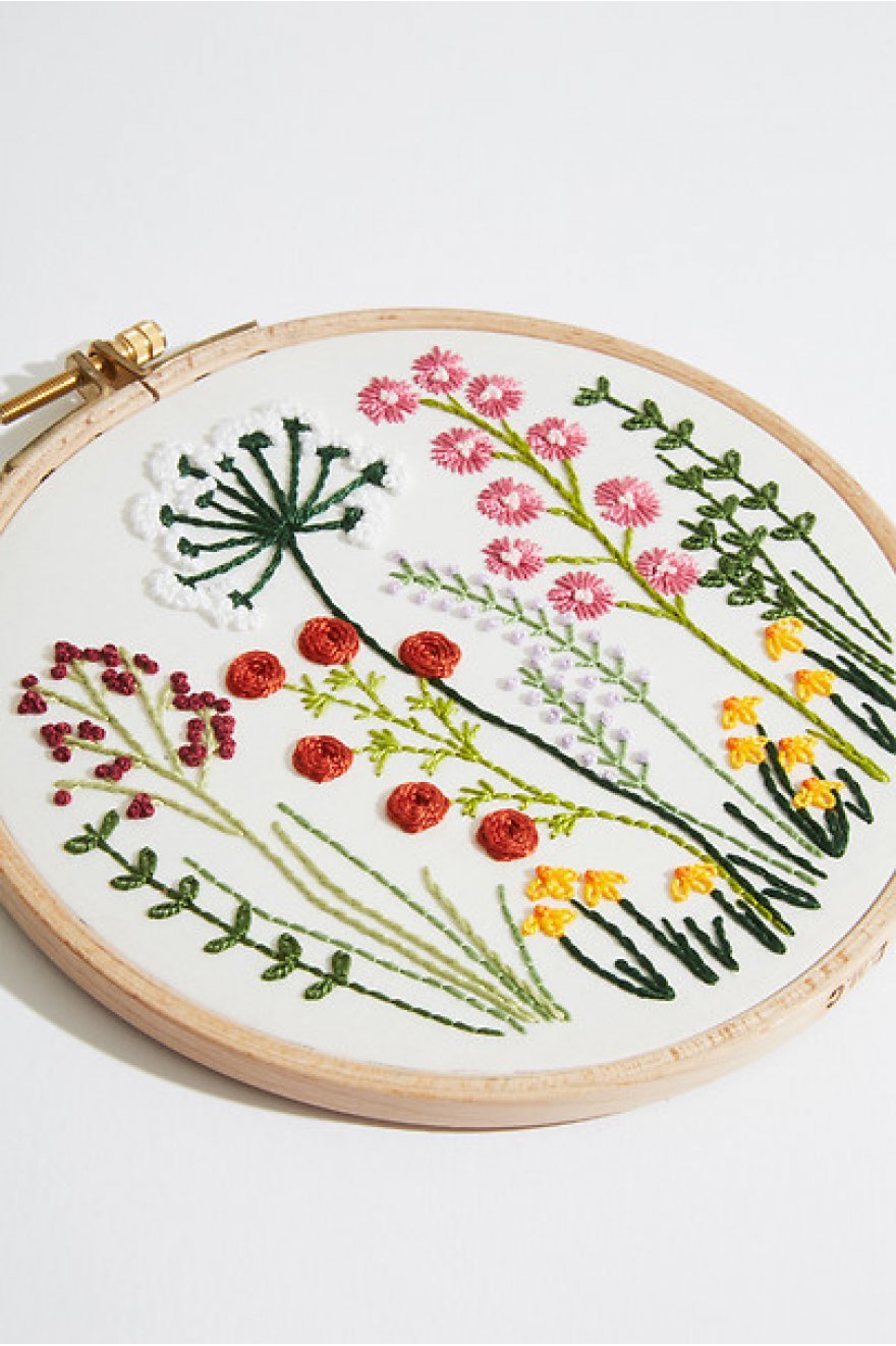 An advanced DMC 3D embroidery kit featuring a charming 'Country Classic' scene with a rustic house, rolling hills, and botanical elements. The design is worked in vibrant Size 5 Pearl Cotton on a 25-count evenweave fabric, creating a thick, rope-like texture. The kit includes a 5-inch embroidery hoop, 13 colors of Pearl Cotton, a needle, and instructions.
