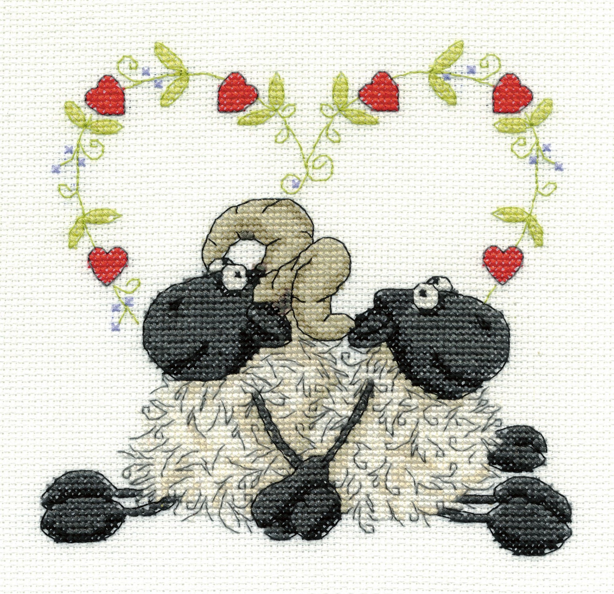 A charming DMC counted cross-stitch kit titled 'Love You Too.' The design features a stylized ram and ewe sitting back-to-back in a symmetrical pose, with a small red heart floating above them. The kit includes 14-count white Aida cloth, premium DMC embroidery floss, a tapestry needle, and clear instructions for a 6x6 inch finished piece.
