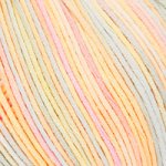 A 50g ball of DMC Natura Multico cotton yarn featuring a soft, matte finish and beautiful variegated color transitions. The image highlights the combed cotton fibers and the multi-ply twist, perfect for lightweight garments, amigurumi, and delicate accessories that require a breathable, high-quality finish in rainbow COlour