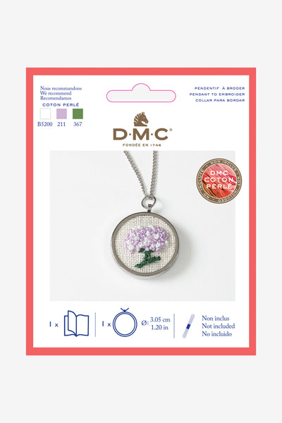 Packaging of DMC round embroidery metal pendant with a floral design, including a chain, displayed on a white background.