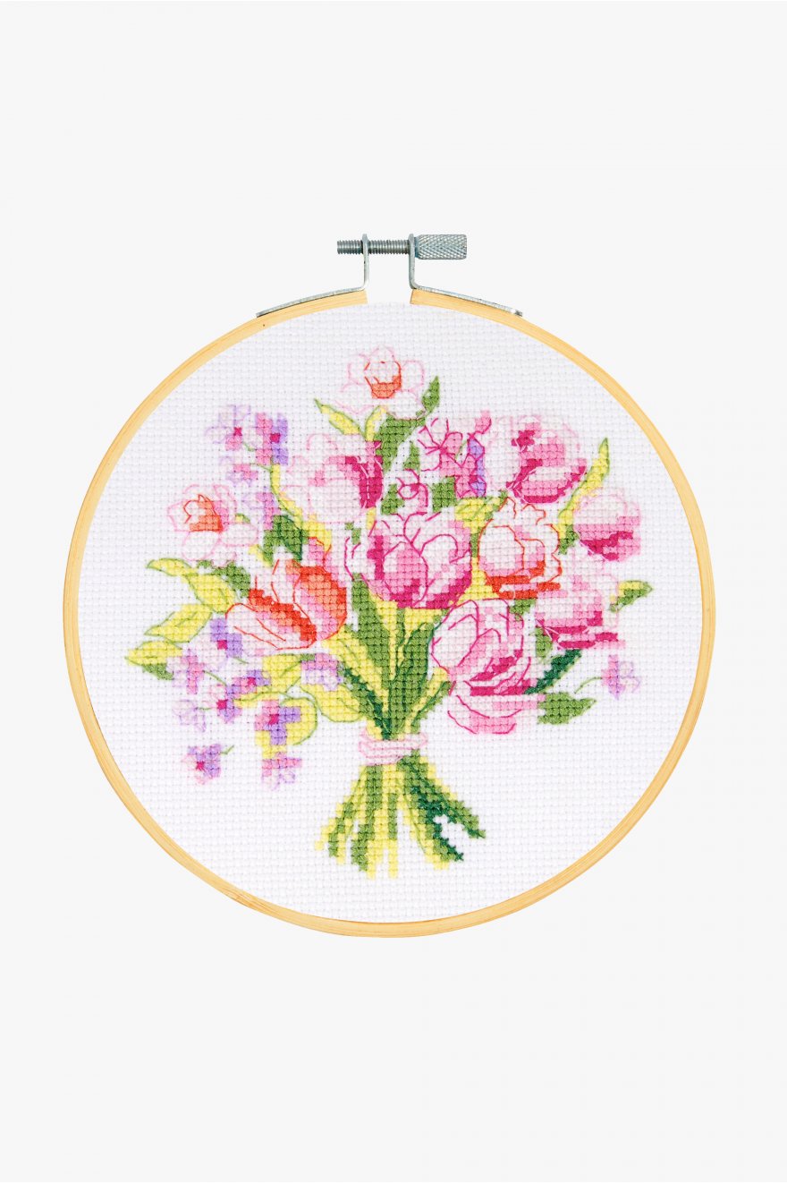 "A beautiful and refreshing DMC counted cross-stitch kit titled 'Spring Bouquet.' The design features a modern, dense bouquet of spring flowers—including delicate pink blooms and lush greenery—in a soft, illustrative style. The kit is all-inclusive, featuring 14-count white Aida fabric, a 6-inch bamboo embroidery hoop, premium DMC embroidery floss, a tapestry needle, and complete instructions."