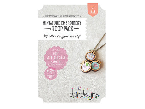 A pack of three Dandelyne 1-inch teeny-tiny mini embroidery hoops with their specialized micro-bolts and silver-plated necklace chains

Packaging of Dandelyne miniature embroidery hoop kit with contents displayed, including three hoops with attached necklace chains and brooch backs.