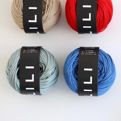 Four skeins of Daruma Lili yarn in beige, red, blue, and gray colors, displayed on a white background.