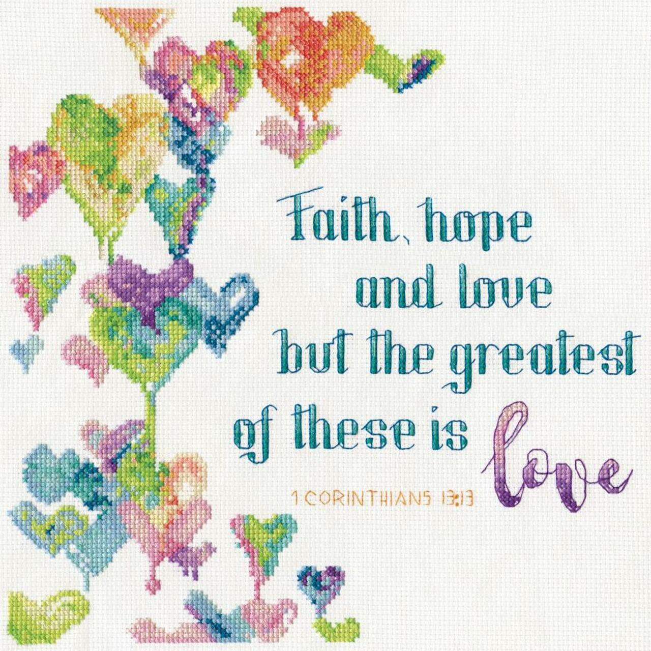 A Design Works counted cross-stitch kit featuring the Bible verse 'Faith, hope and love. But the greatest of these is love' from 1 Corinthians 13:13. The design is presented in an elegant layout on 14-count white Aida fabric. The kit includes a pre-sorted thread palette with 100% cotton floss, a needle, a clear pattern chart, and instructions.