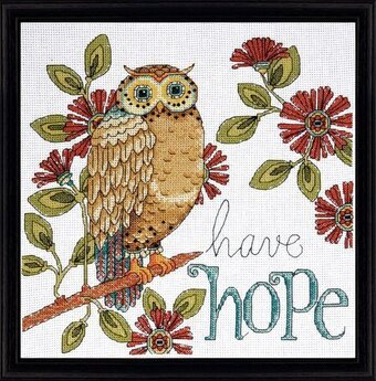 An inspirational Design Works cross-stitch kit titled 'Hope Owl.' The design features a colorful, decorative owl with the word 'Hope' integrated into the pattern. The kit includes 14-count white Aida cloth, premium embroidery threads, accent beads for added shimmer, a needle, and clear instructions for a 10-inch square finished piece.