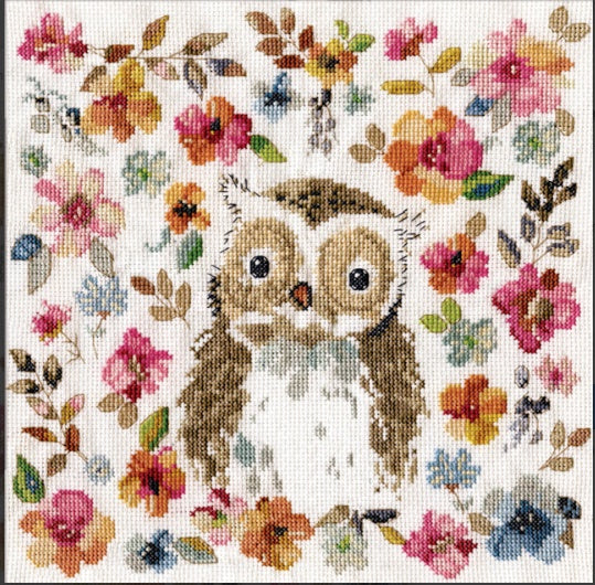 A modern Design Works counted cross-stitch kit titled 'Watercolour Owl.' The design features a stylized owl with large, expressive eyes, surrounded by an artistic explosion of flowers in watercolour-style hues of turquoise, magenta, and gold. The kit includes 14-count white Aida fabric, a pre-sorted thread palette, and a tapestry needle