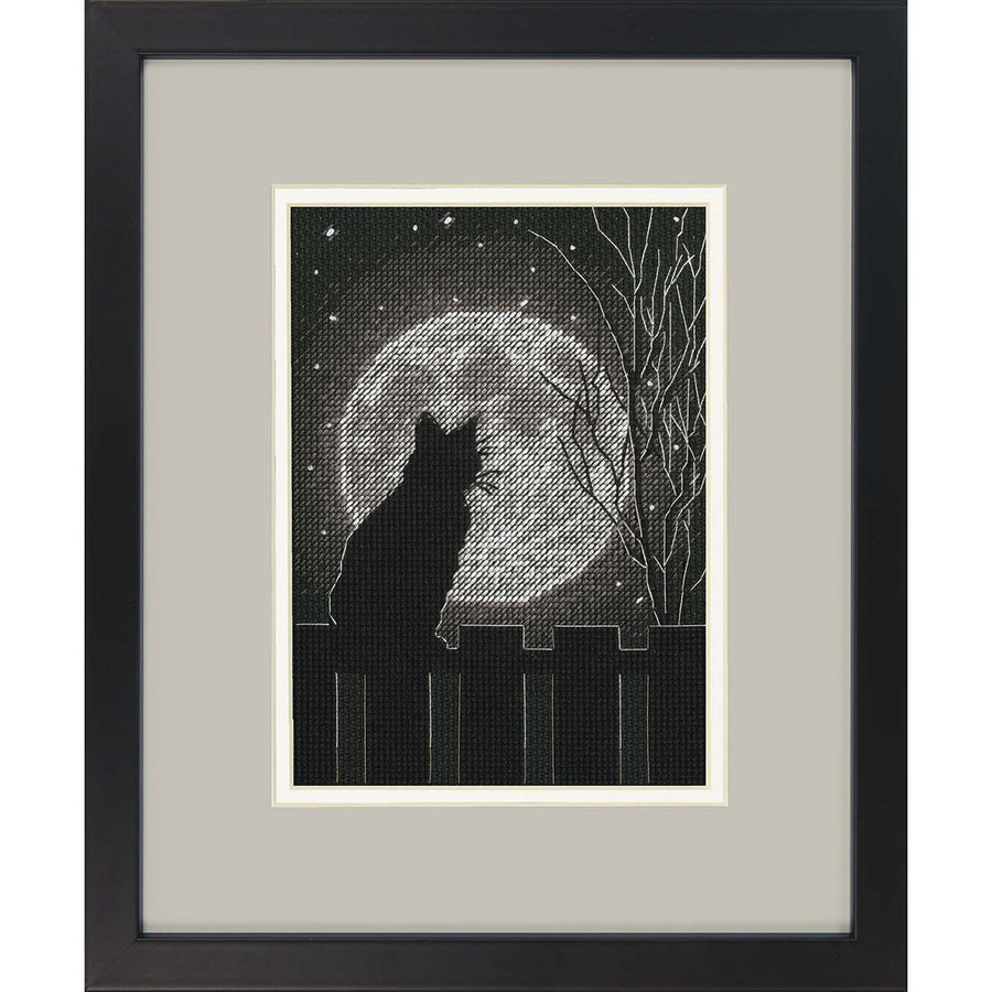 A cross stitch kit depicting a black cat with a full moon in the background, enclosed in a black frame.