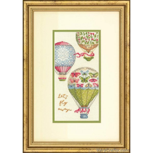 A highly detailed vertical Dimensions Gold Collection cross-stitch kit titled 'Let's Fly Away.' The design features several vibrant, patterned hot air balloons drifting over a scenic landscape of rolling hills and distant water. The kit includes 18-count ivory Aida cloth, pre-sorted embroidery threads, a needle, and a pattern sheet for a 4x8 inch finished piece