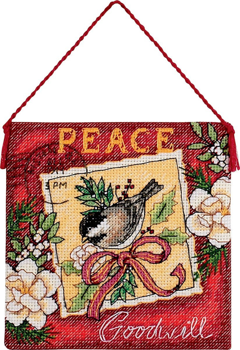 Close-up of the "Peace" cross stitch ornament design, showcasing the delicate metallic gold thread accents and the fine, dense stitching that creates a sophisticated, heirloom-quality holiday motif.