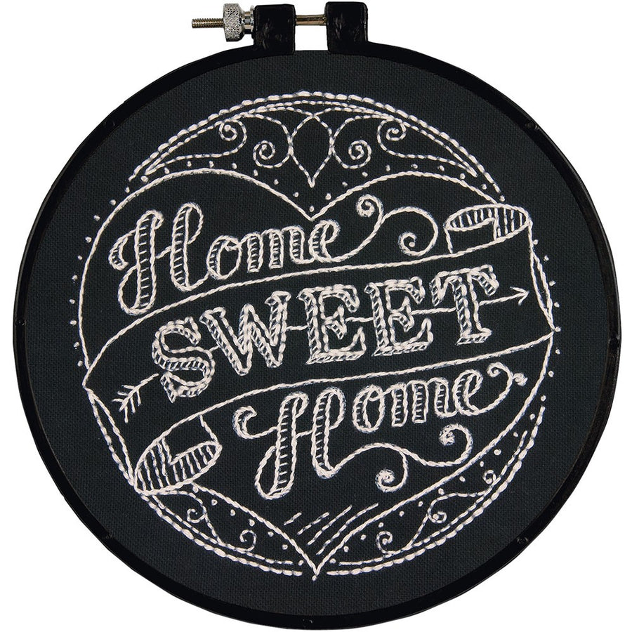 Embroidery hoop with 'Home Sweet Home' text in white on a black background, enclosed in a 6-inch plastic hoop.