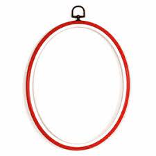 An oval-shaped flexible embroidery hoop measuring 3.5 inches by 5 inches. The outer ring features a realistic dark woodgrain texture and a decorative hanging brass-style ring at the top. The inner ring is smooth plastic, designed to hold fabric tight. This dual-function hoop can be oriented either vertically or horizontally for final display in Red colour