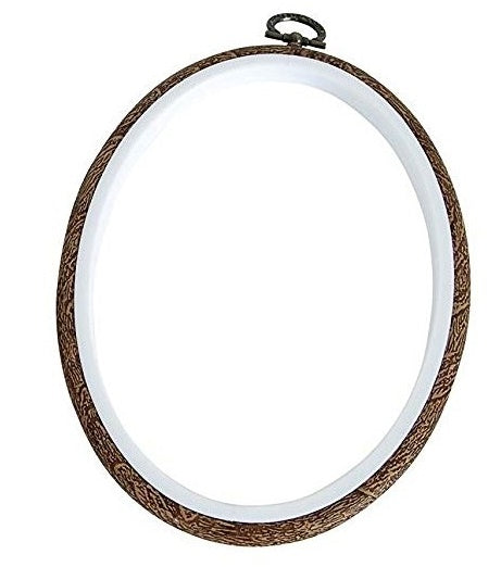 An oval embroidery hoop with a wood grain appearance on the outer layer, designed to hold fabric for embroidery work.