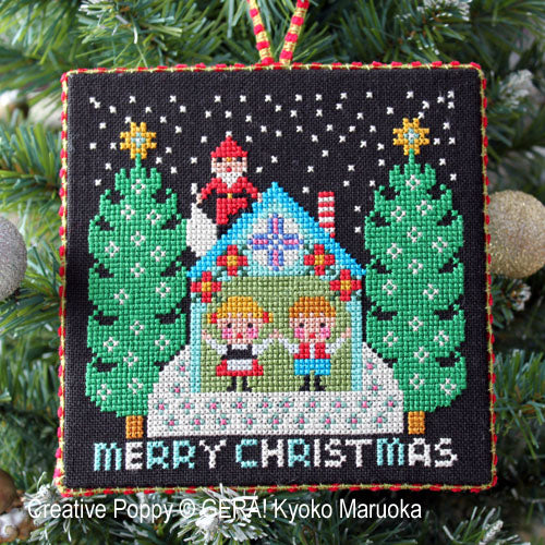 A cross-stitched ornament depicting Santa Claus with a Merry Christmas message, designed by Gera! by Kyoko Maruoka, with a green and white color scheme.