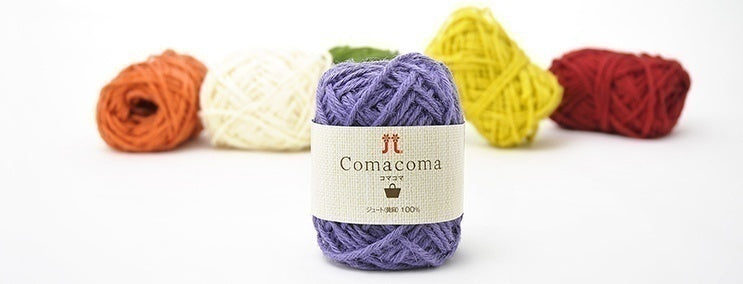 Balls of multicolored jute yarn with a label in the center, displayed against a white background.