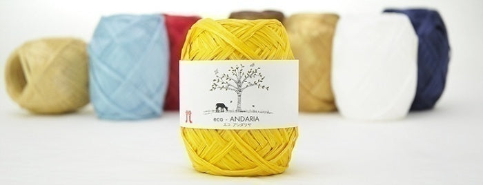A vibrant selection of Hamanaka Eco Andaria yarn cakes in various summer colors, made in Japan