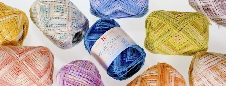 Hamanaka Wash Cotton Gradation yarn. The image captures the subtle, elegant color shifts within the strand, showing the transition between harmonious shades. The yarn has a slightly lustrous, high-definition twist, highlighting its premium Japanese quality and soft-yet-structured texture.
