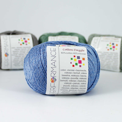 A 50g skein of Cotton Dazzle yarn in a sky blue vibrant shade, showcasing the subtle reflective shimmer and smooth plied texture of the cotton-viscose blend