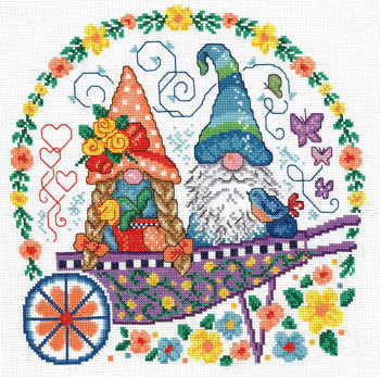 A cross stitch kit depicting two colorful garden gnomes in a decorative cart, with floral and butterfly motifs in the background.