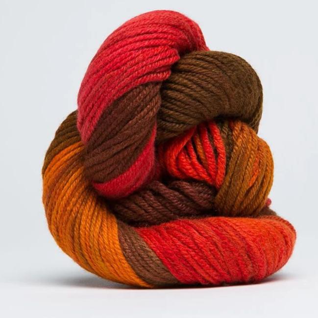 A skein of Jade Sapphire 100% Cashmere Yarn in a hand-dyed colorway, featuring shades of red orange and brown