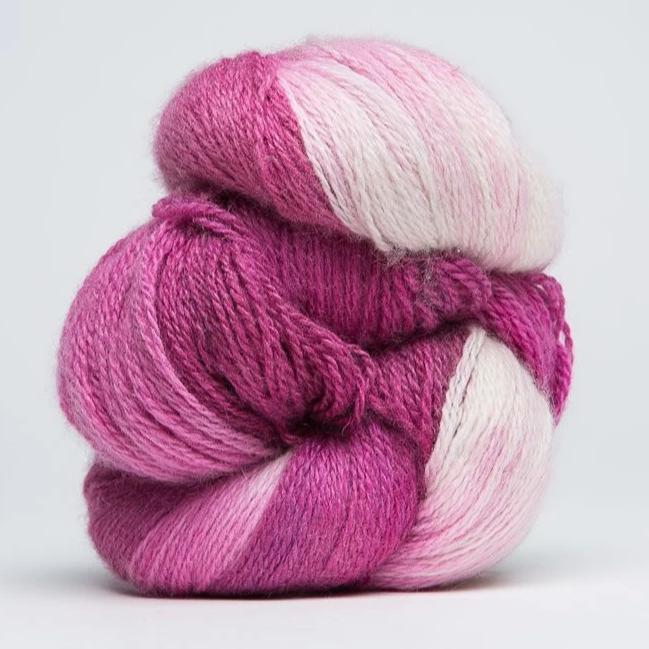 A delicate skein of hand-dyed Jade Sapphire yarn, showcasing a sophisticated blend of 55% silk and 45% cashmere in pink shades
