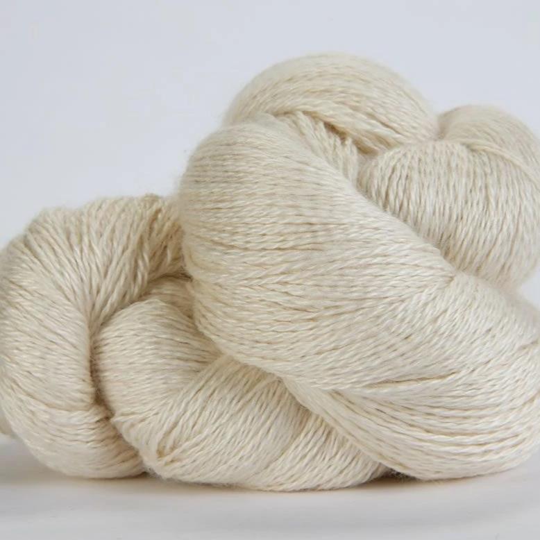 Jade Sapphire hand-dyed 50% silk and 50% yak lace yarn from Mongolia; a 100g skein with 700 yards for premium lace knitting."
"Close-up of hand-dyed Jade Sapphire exotic fiber yarn in Off White, showing the unique tonal variations and silken luster of the yak-silk blend."