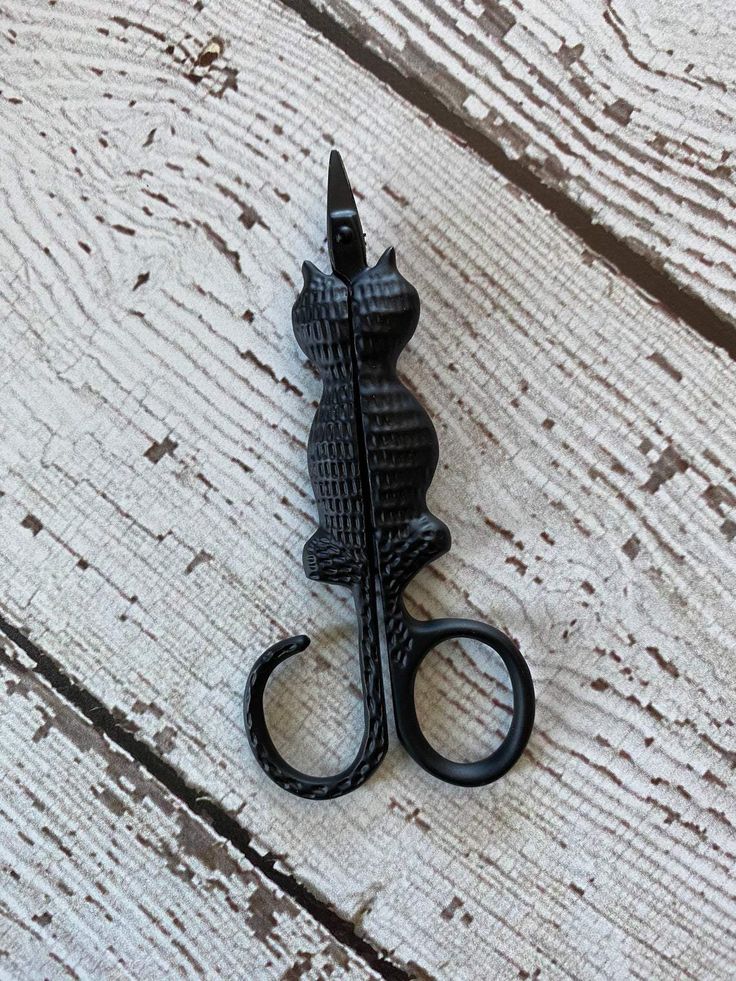 "A pair of Kelmscott Designs 'Cat Snips' scissors featuring a unique cat-shaped silhouette where the handles form a playful curling tail. These 3.75-inch specialty embroidery scissors are shown with their sharp, precision blades and a vintage-inspired finish, ideal for boutique needlework collections."