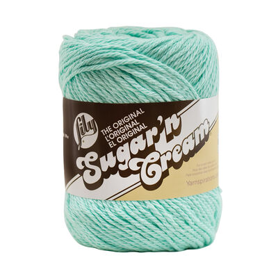 A skein of Lily Sugar N' Cream 100% cotton yarn in a solid color. The texture is soft yet sturdy, showing the natural matte finish of the cotton fibers. The packaging clearly displays the Lily brand logo and weight options, ideal for durable kitchen and bathroom DIY projects."